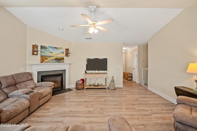 living room with ceiling fan, light hardwood / wood-style floors, and lofted ceiling