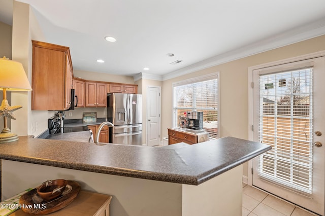 kitchen with kitchen peninsula, a breakfast bar, light tile patterned floors, and appliances with stainless steel finishes