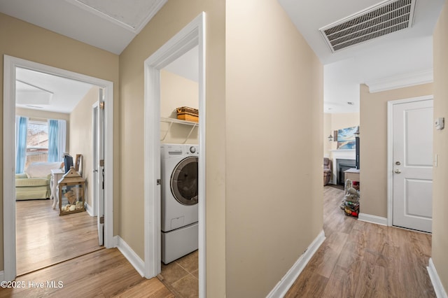 laundry area with washer / clothes dryer and light hardwood / wood-style floors