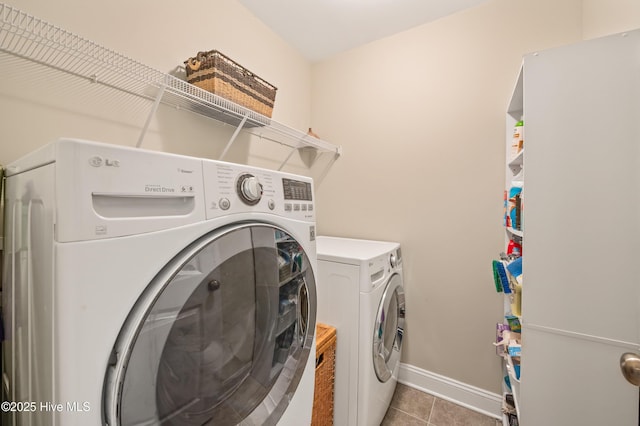 laundry room featuring washer and dryer and light tile patterned floors