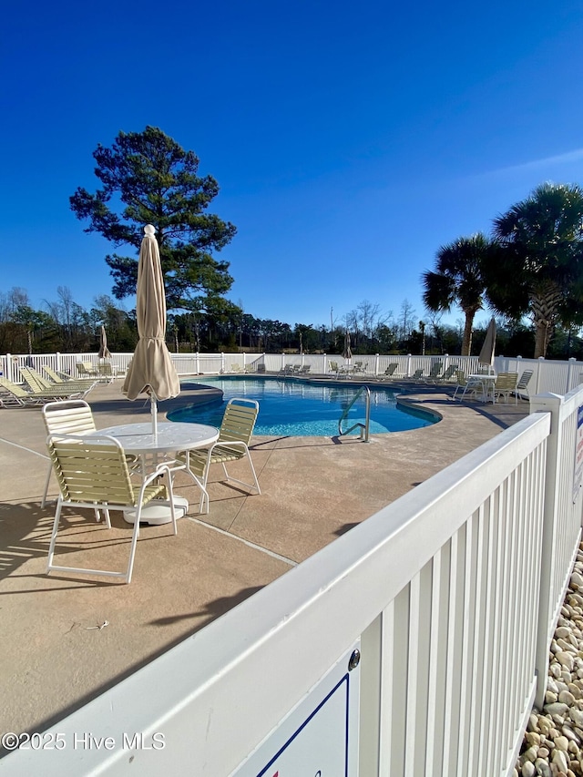 pool with fence and a patio