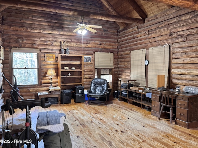 home office featuring beamed ceiling, rustic walls, high vaulted ceiling, light wood-type flooring, and ceiling fan