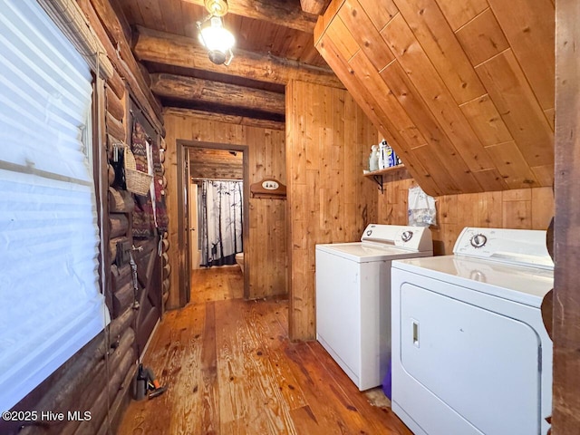 laundry room featuring wooden ceiling, wooden walls, light hardwood / wood-style flooring, and washing machine and clothes dryer