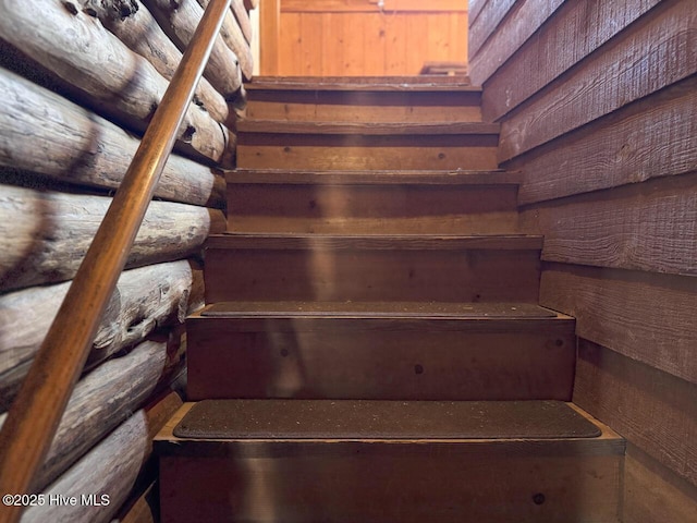 staircase with rustic walls