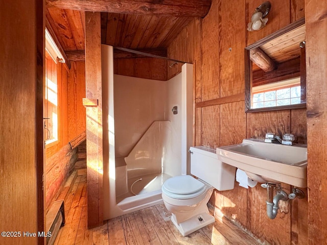 full bathroom featuring toilet, hardwood / wood-style floors, wood ceiling, bathing tub / shower combination, and wood walls