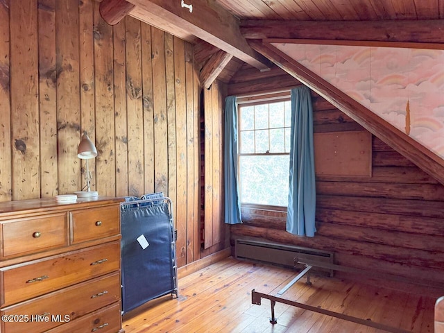 additional living space with wood ceiling, a baseboard heating unit, wooden walls, lofted ceiling with beams, and light hardwood / wood-style flooring