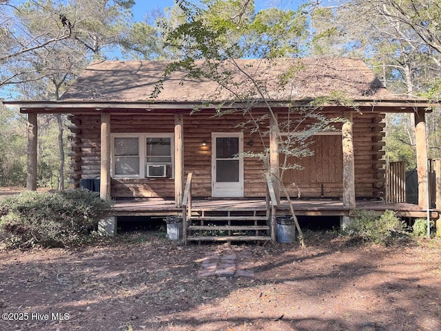 log home with covered porch and cooling unit