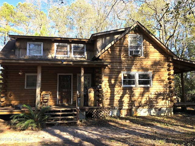 log cabin with a porch and cooling unit