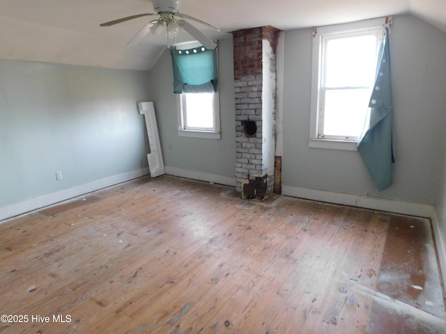 unfurnished living room with plenty of natural light, light hardwood / wood-style flooring, vaulted ceiling, and ceiling fan