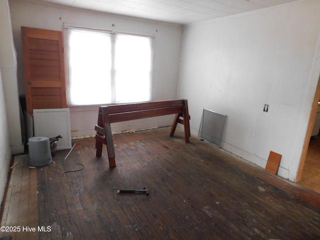 empty room with dark wood-type flooring and a healthy amount of sunlight