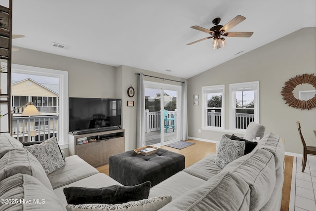 living room featuring lofted ceiling, ceiling fan, and light hardwood / wood-style flooring