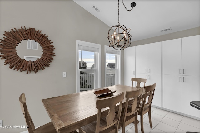 dining room featuring an inviting chandelier, vaulted ceiling, and light tile patterned floors