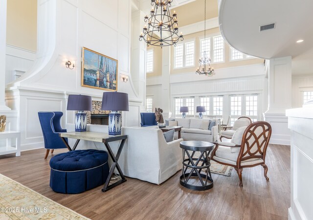 interior space featuring decorative columns, a high ceiling, wood-type flooring, and crown molding