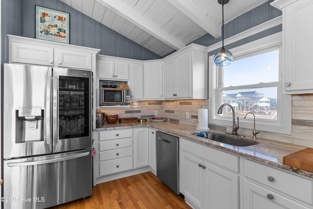 kitchen featuring vaulted ceiling with beams, white cabinetry, sink, and appliances with stainless steel finishes