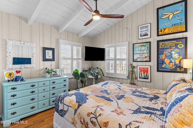 bedroom with ceiling fan, lofted ceiling with beams, wood walls, wood ceiling, and hardwood / wood-style flooring