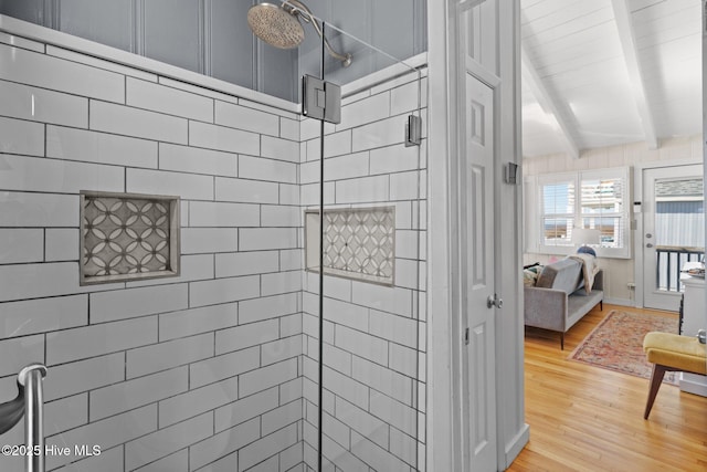 bathroom featuring walk in shower, beamed ceiling, and hardwood / wood-style flooring