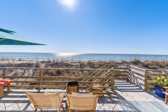 view of patio featuring a water view and a beach view