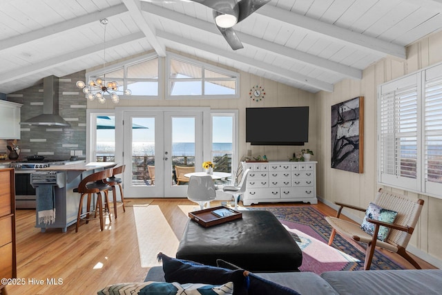 living room with lofted ceiling with beams, light hardwood / wood-style flooring, and french doors