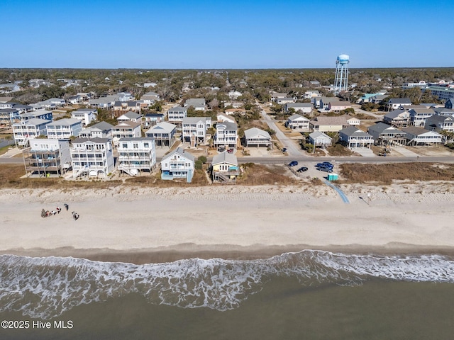 birds eye view of property featuring a water view and a beach view