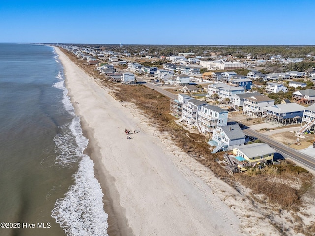 birds eye view of property featuring a water view and a beach view