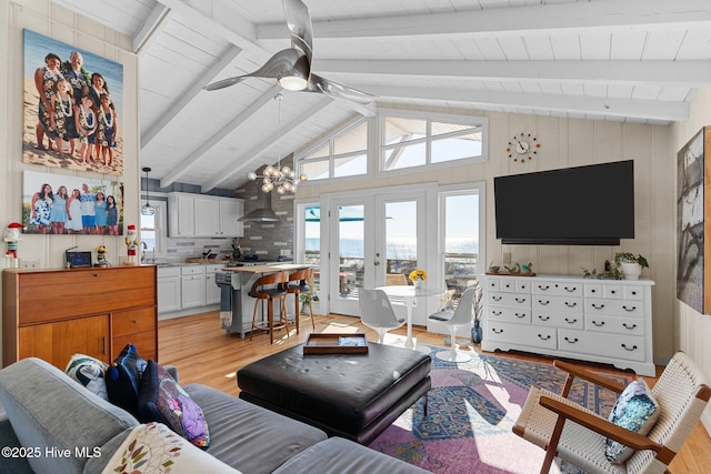 living room featuring french doors, light wood-type flooring, ceiling fan with notable chandelier, sink, and lofted ceiling with beams