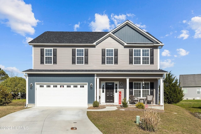 view of front of property featuring covered porch, a garage, and a front yard