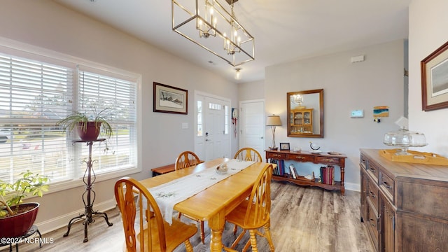 dining space featuring a notable chandelier and light wood-type flooring