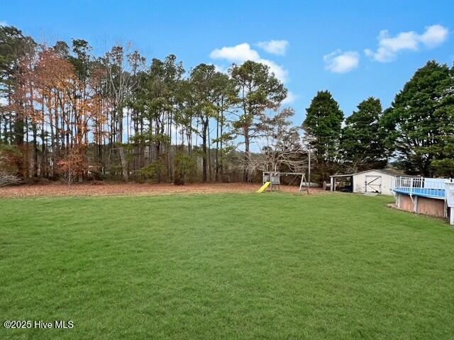 view of yard with a playground and a storage shed