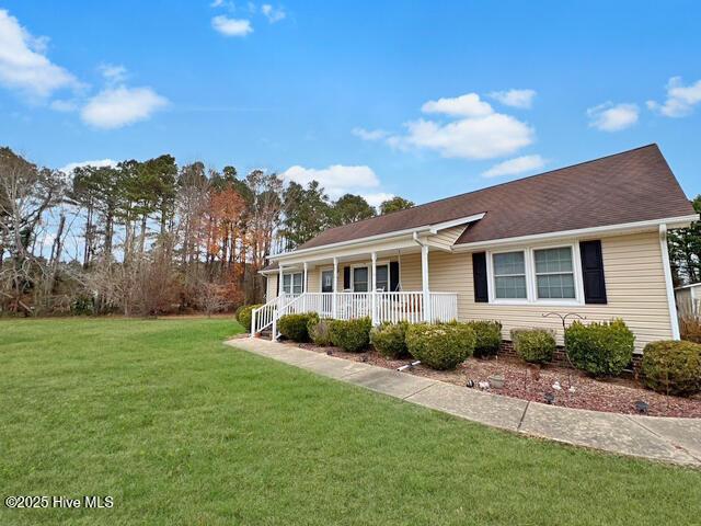 ranch-style home with covered porch and a front yard