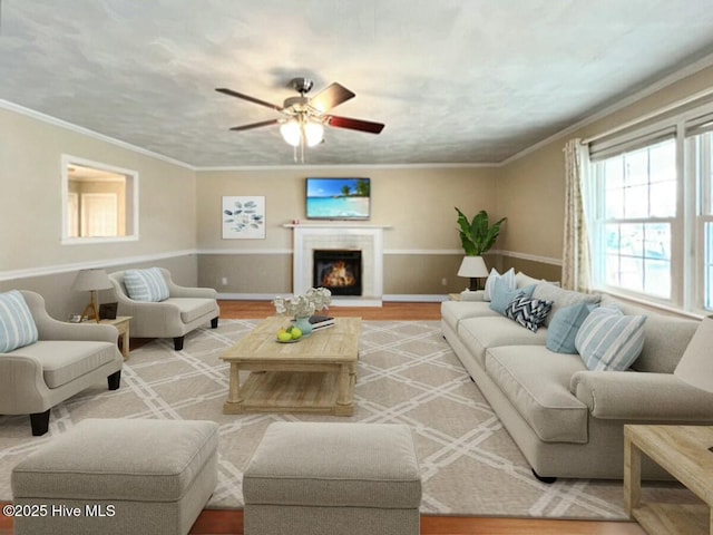 living room featuring ceiling fan, light hardwood / wood-style floors, and crown molding