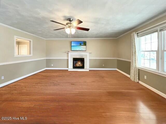 unfurnished living room with hardwood / wood-style floors, ceiling fan, and crown molding