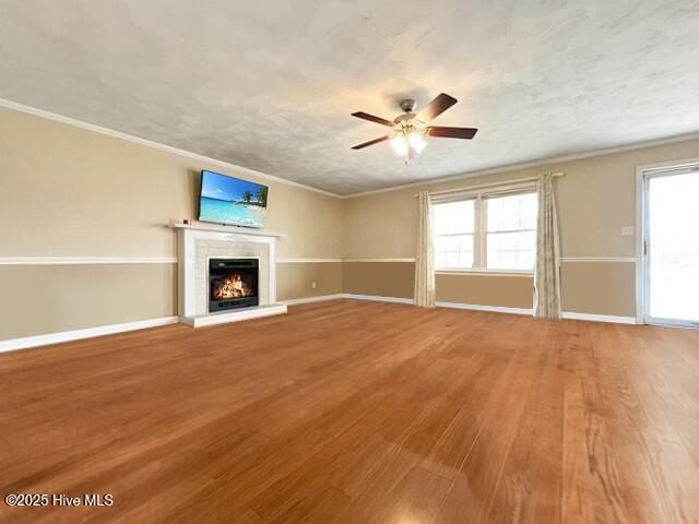 unfurnished living room with a fireplace, hardwood / wood-style floors, and crown molding