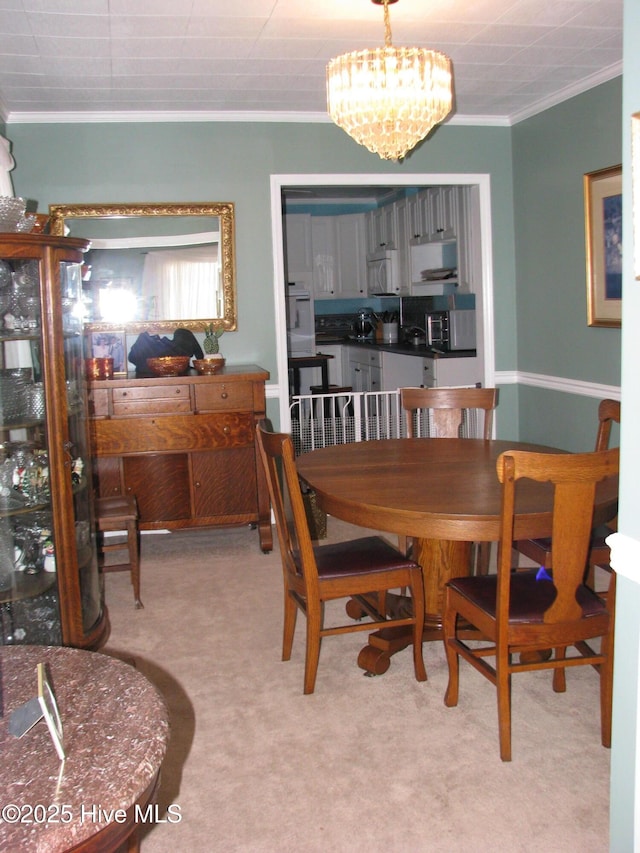 dining space with light colored carpet, crown molding, and a chandelier