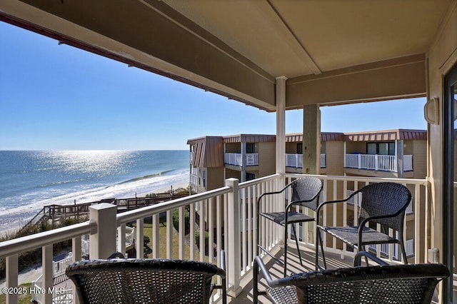 balcony with a water view and a beach view