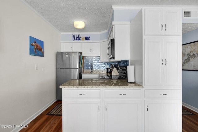 kitchen featuring dark wood-type flooring, crown molding, tasteful backsplash, white cabinetry, and stainless steel appliances