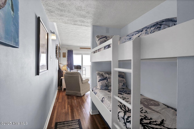 bedroom featuring a textured ceiling and dark hardwood / wood-style flooring