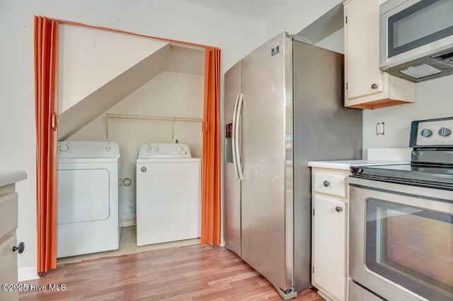 kitchen featuring appliances with stainless steel finishes, light hardwood / wood-style flooring, and washing machine and clothes dryer