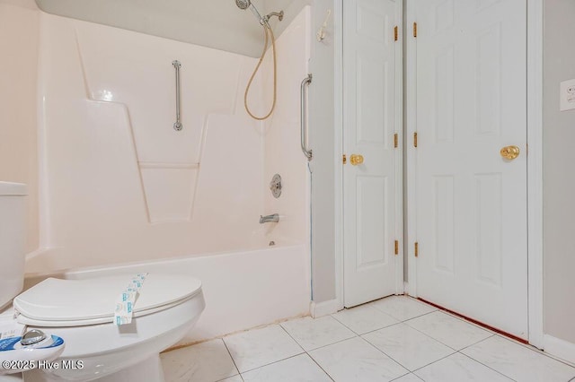 bathroom featuring tile patterned flooring, toilet, and tub / shower combination