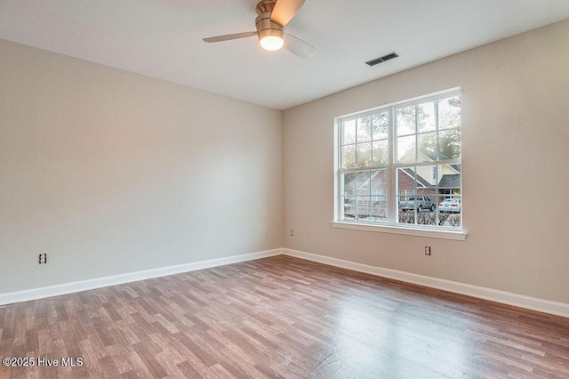 empty room with hardwood / wood-style floors and ceiling fan