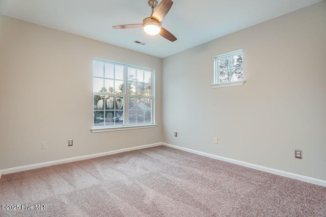 empty room featuring carpet, a wealth of natural light, and ceiling fan