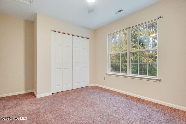 unfurnished bedroom featuring ceiling fan, a closet, and carpet