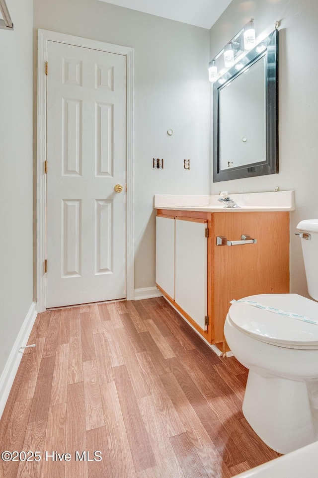 bathroom with vanity, wood-type flooring, and toilet