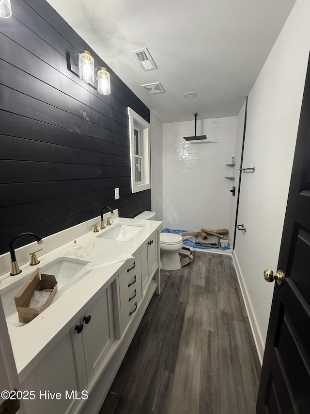 bathroom with vanity, toilet, hardwood / wood-style floors, and a shower