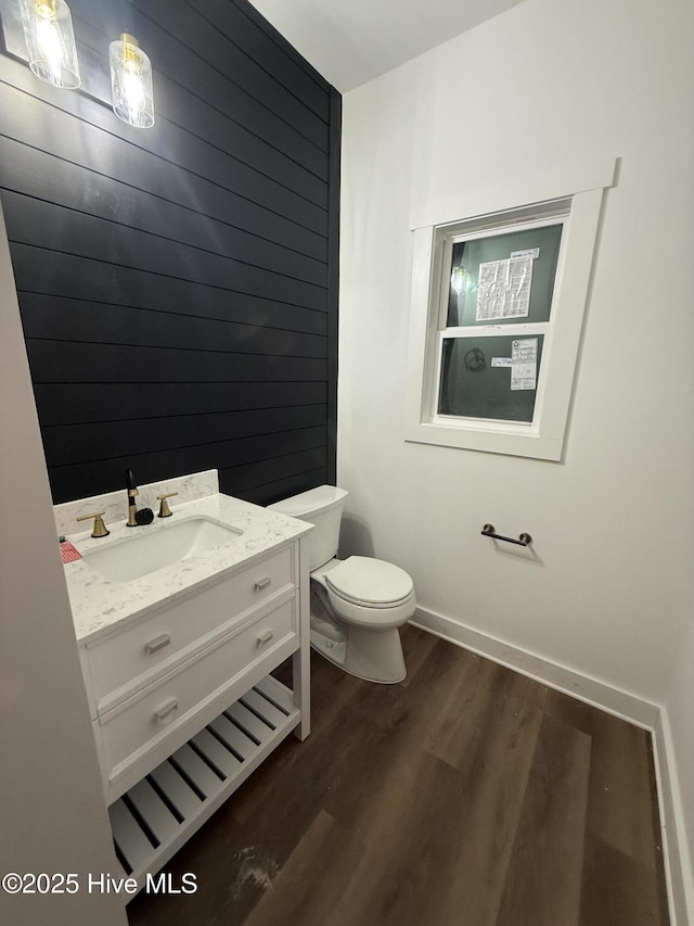 bathroom with wood-type flooring, vanity, and toilet