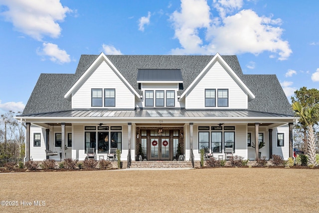 view of front of house with a porch, french doors, and a front lawn