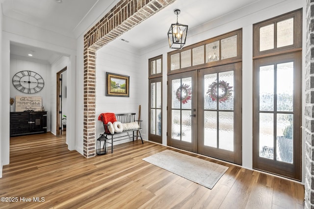 entrance foyer featuring a chandelier, french doors, and hardwood / wood-style floors