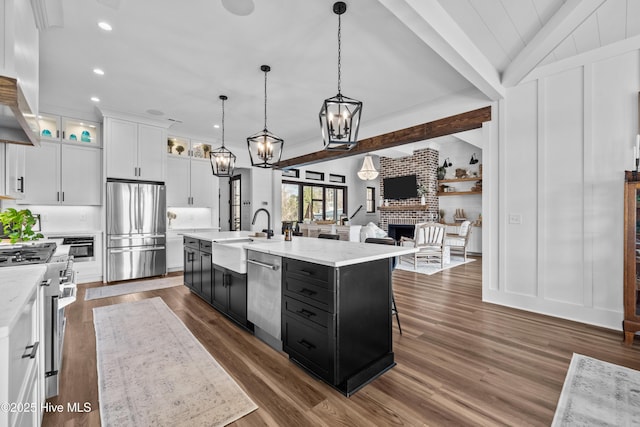 kitchen featuring a center island with sink, white cabinets, stainless steel appliances, and sink