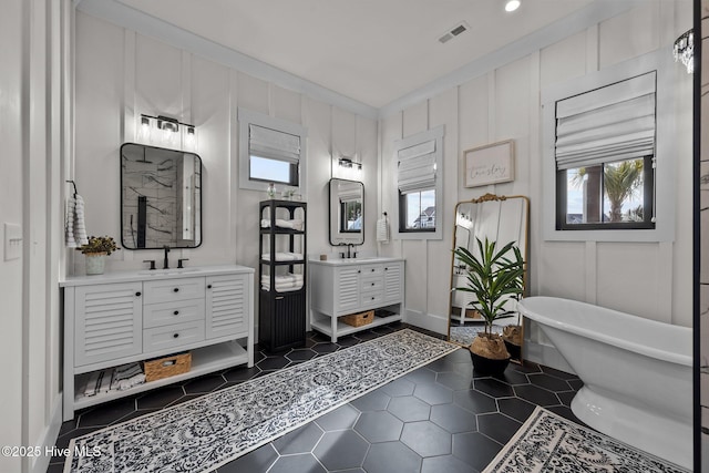 bathroom with a bathtub, vanity, and ornamental molding