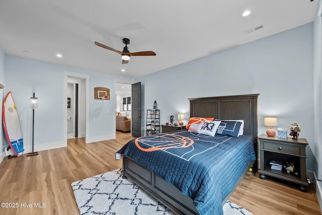 bedroom with ensuite bathroom, light hardwood / wood-style flooring, and ceiling fan