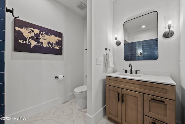 bathroom featuring tile patterned flooring, vanity, and toilet